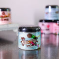 Jar labeled 'Florida Vacay' on a reflective surface with blurred background