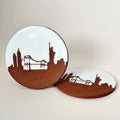 Two ceramic coasters with city skyline design on a white background