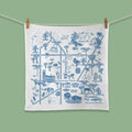 White towel with blue graphics of Jacksonville, FL, hanging on a line against a green background