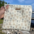 Person holding a pouch with ice cream cone pattern against a natural background