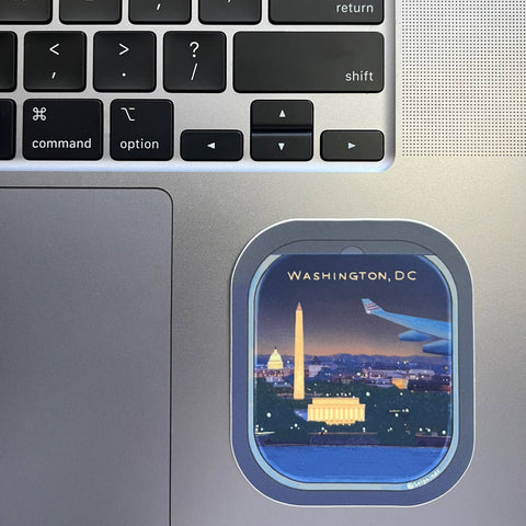 Laptop with a window sticker of Washington, DC at night