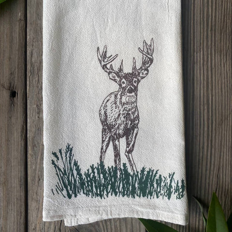 White towel with a black deer illustration on a wooden surface