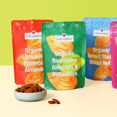 Assorted bags of organic snacks on a light surface with a green background