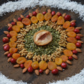 Decorative arrangement of dried fruits and nuts on a wooden board with coconut flakes around.