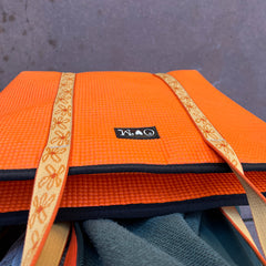 Orange mat with gold border on a gray surface