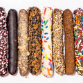 Assorted chocolate-dipped cookies with different toppings on a white background