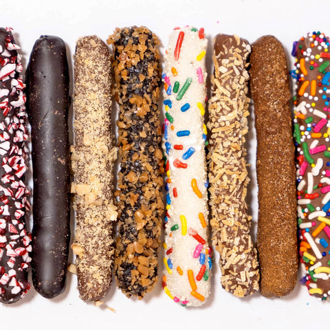 Assorted chocolate-dipped cookies with different toppings on a white background