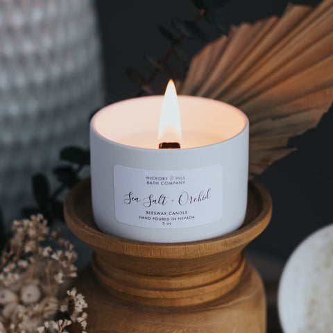 Candle with a label on a wooden holder against a dark background