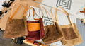 Four brown leather handbags on a cutting mat with tools in the background