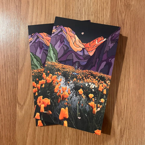 Two greeting cards with nature-themed designs on a wooden surface
