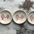 Three ceramic dishes with red bridge design on a wooden surface