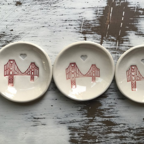 Three ceramic dishes with red bridge design on a wooden surface