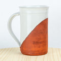 White mug with a brown accent on a wooden surface