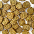 Close-up of green pet food pellets on a white background