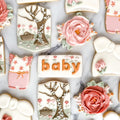 Decorative cookies with floral designs, gift boxes, and 'baby' text on a white surface.