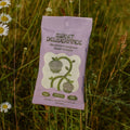 Sweet Deliverance granola packet in a field with wildflowers