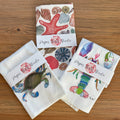 Set of paper products with sea-themed designs on a wooden surface