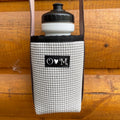 White textured bottle holder with black cap and logo on a wooden surface