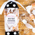 Packaged sea salt caramels with a 'Kindred Cooks' label on a wooden surface.