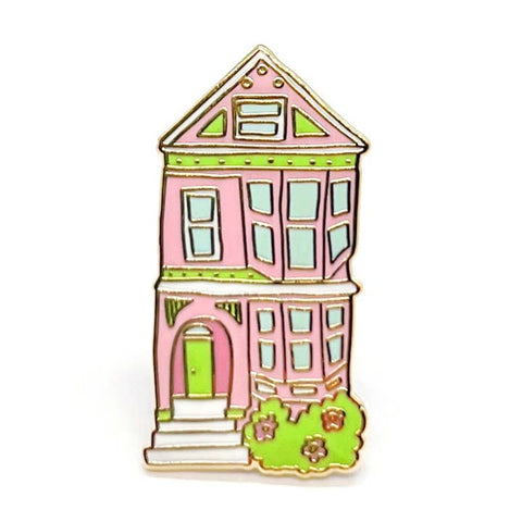 Pink house-shaped pin with green accents on a white background