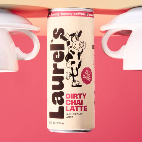 Can of Laurel's Dirty Chai Latte with a cow illustration on a pink background