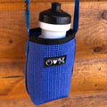 Blue bottle holder with a black lid on a wooden surface
