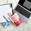 Laptop, notebook, and cookie on a fluffy white surface