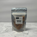 Packaged peanut brittle with 'Sugar & Salt' label on a marble surface