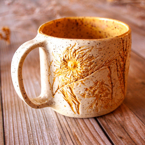 Ceramic mug with floral design on a wooden surface
