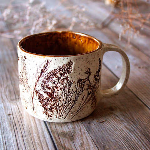 Ceramic mug with floral design on a wooden surface