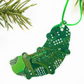 Christmas ornament shaped like a green caterpillar made of circuit board material, hanging on a branch.