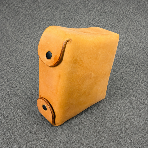 Brown leather case with a black button on a gray textured background