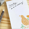 Note with 'Saturday Go Bird Watching!' text and bird illustration on a wooden surface