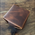 Brown leather wallet on a wooden surface