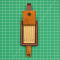 Brown leather luggage tag on a green grid background