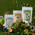 Three 'Sweet Deliverance' product packages surrounded by fruits and flowers on a green background