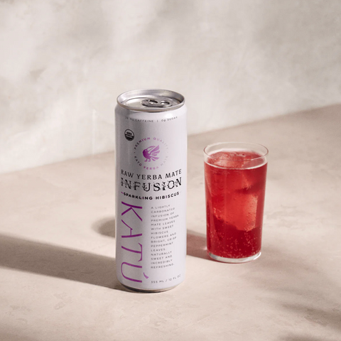 Katu raw yerba mate infusion can with a glass of red drink on a beige background