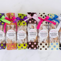 Assorted caramel packages with colorful ribbons on a white background